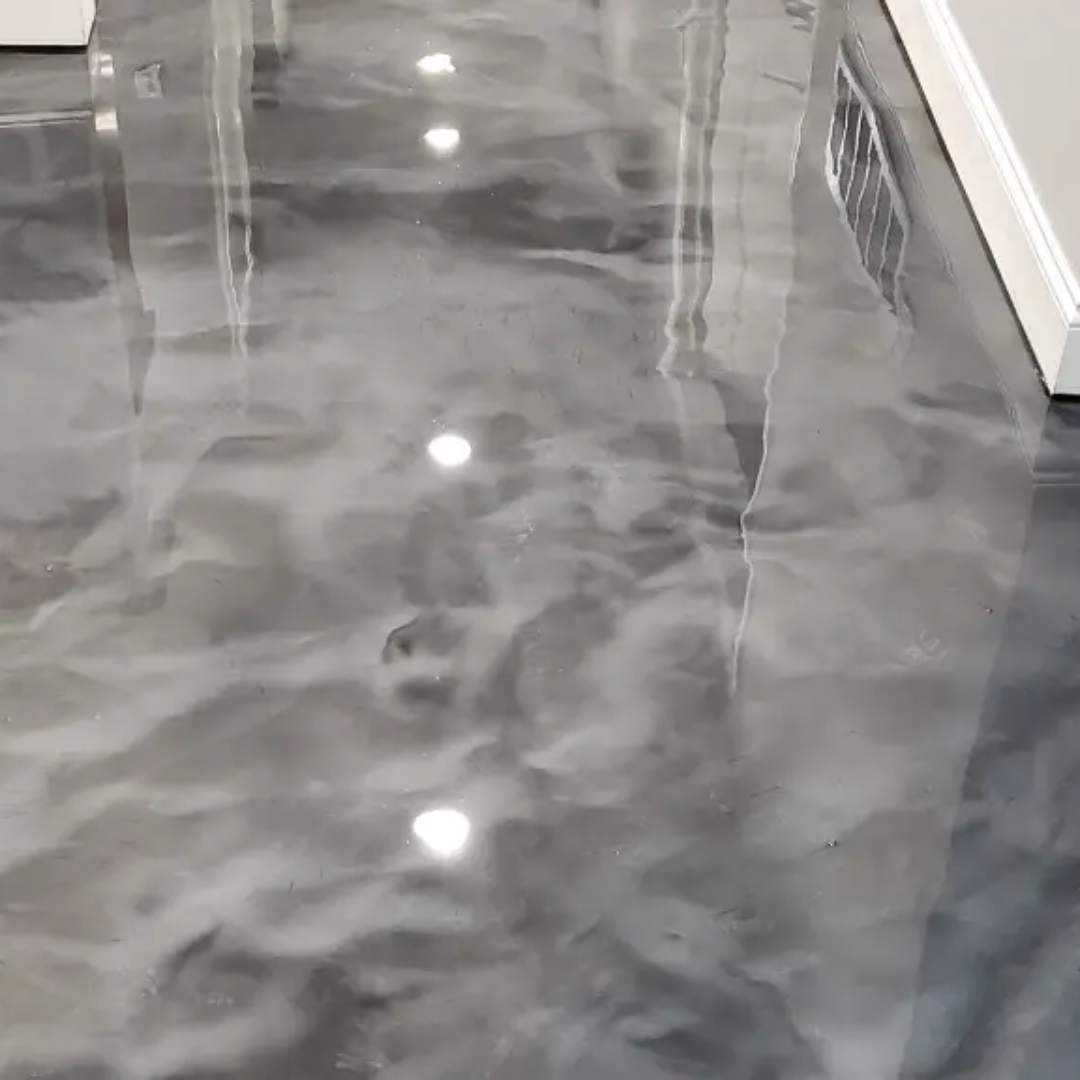 Shiny, swirling gray and white epoxy floor reflecting overhead lights in a room.