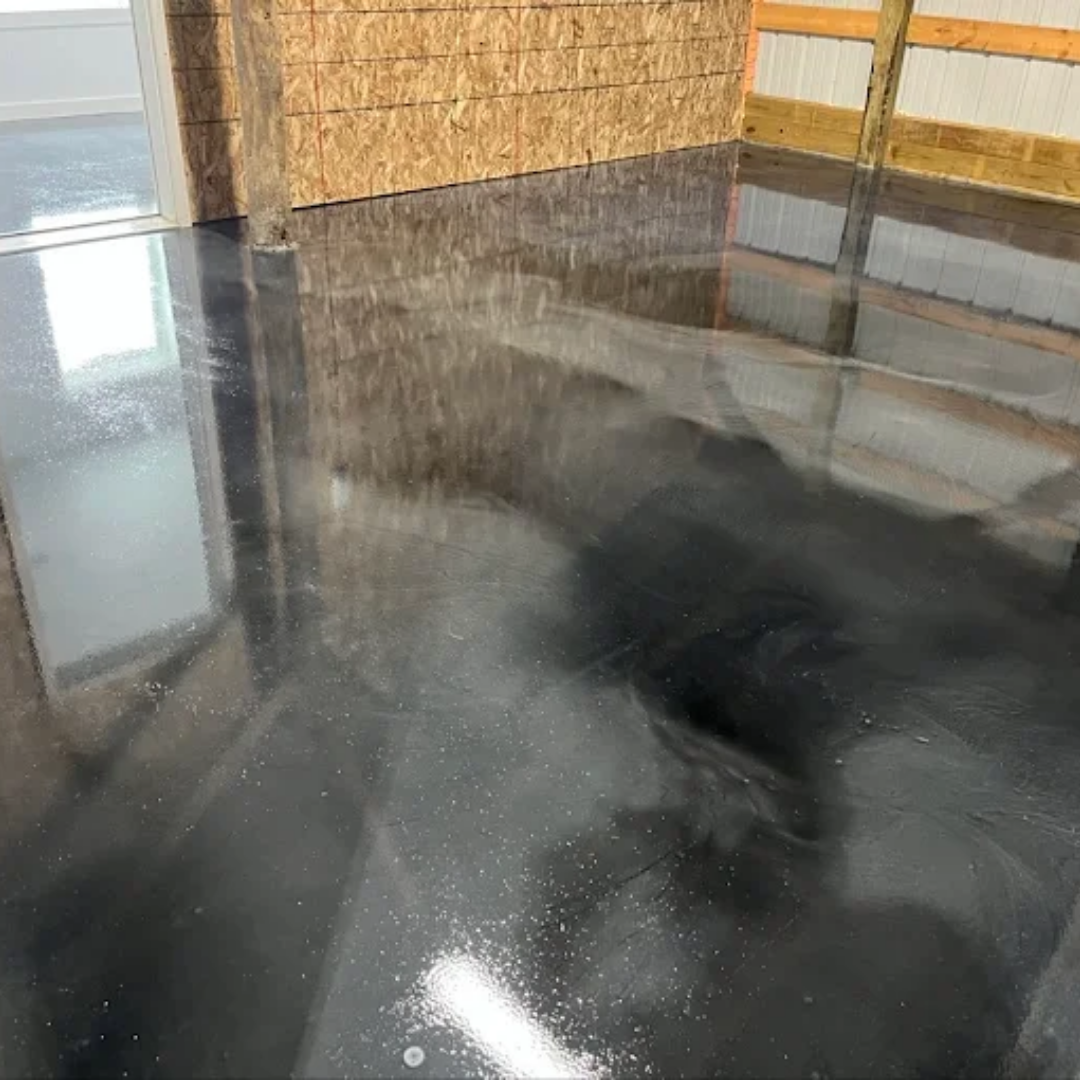 Shiny black epoxy floor with light reflections; interior setting.