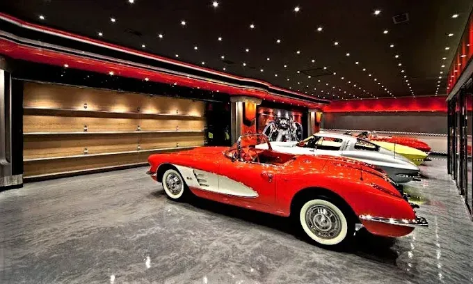 Luxury garage with red classic Corvette, other sports cars, and shelving.