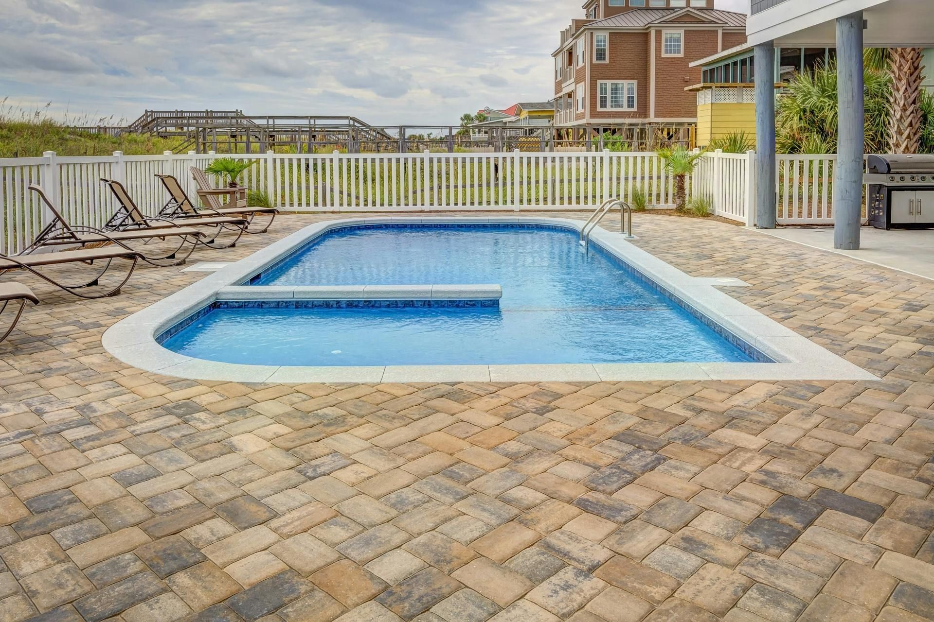 Outdoor patio seating area with chairs, fire pit, and fireplace.